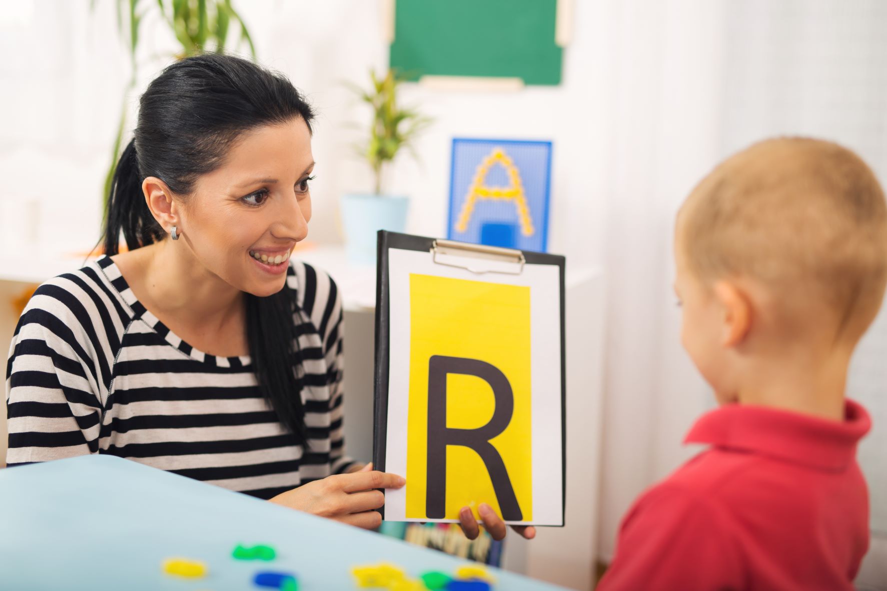 Woman showing letters to a child.