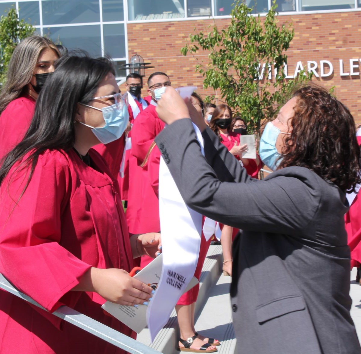 Vocational Nursing faculty puts stole around new graduate.