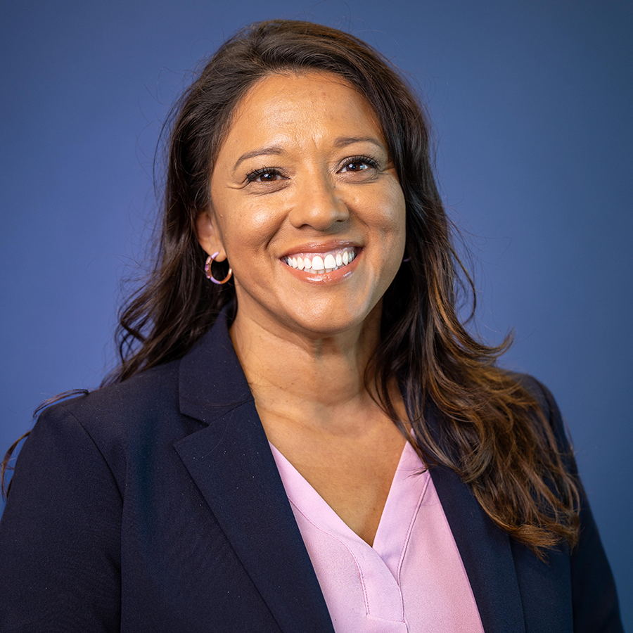 Sandra Guzman headshot, VP of Student Affairs, headshot setting in front of a blue background. Sandra is smiling.