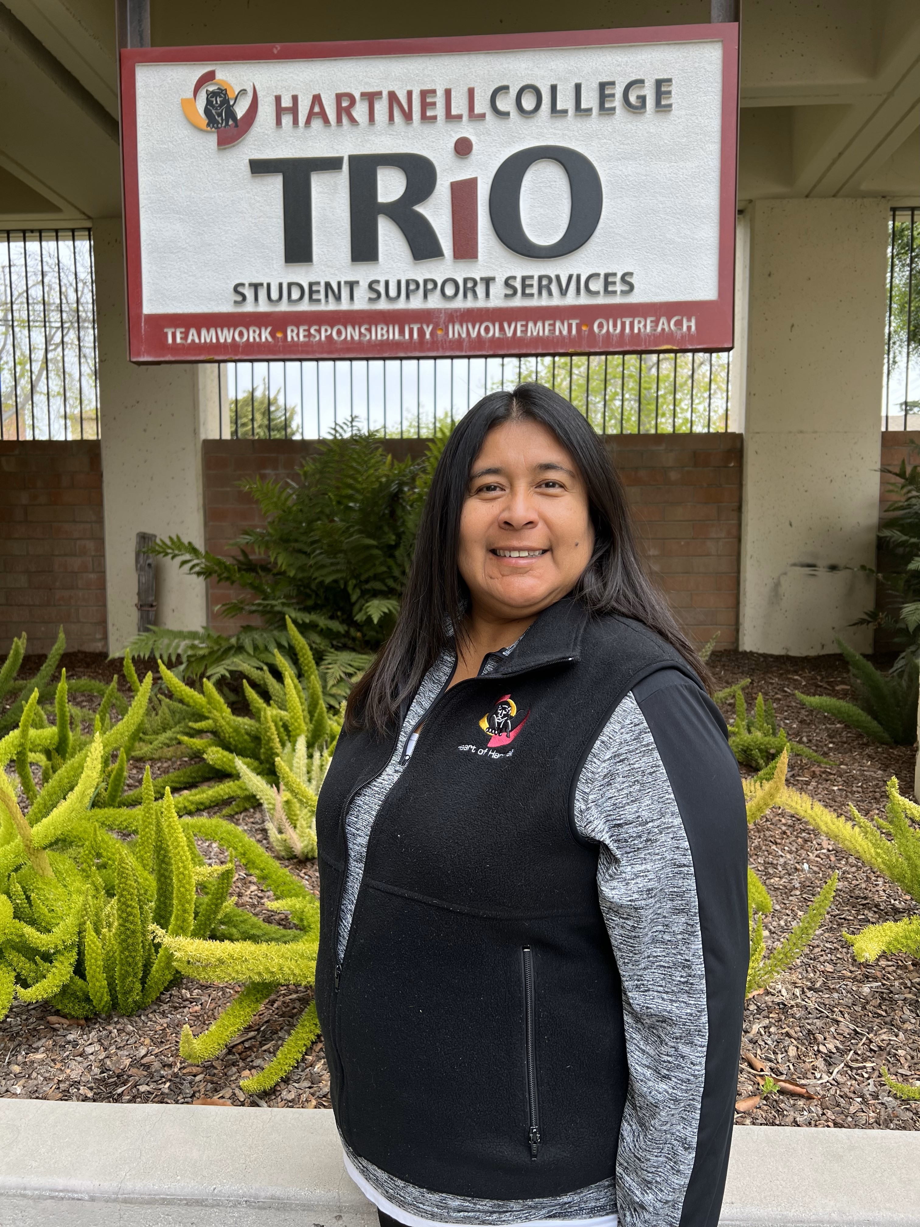 Norma Nichols standing in front of TRIO sign